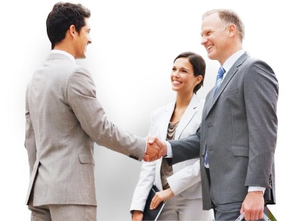 Two businessmen shake hands while businesswoman watches.